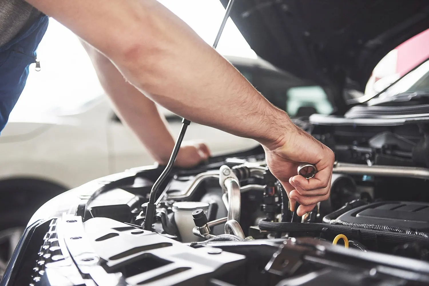 Diesel mechanic working under the hood of a truck