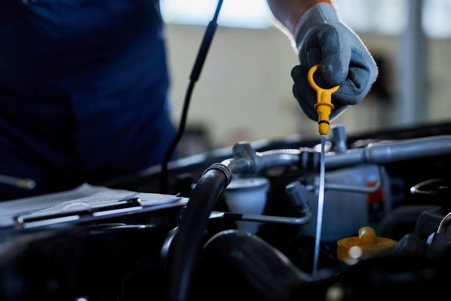 Technician checking engine oil in the workshop